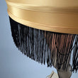 Load image into Gallery viewer, 50 inch full size leg lamp close up of gold shade and black fringe.

