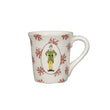 Load image into Gallery viewer, White mug with red floral patterns and a green character design on a white background
