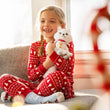 Load image into Gallery viewer, Smiling girl in Christmas pajamas hugging a white Elf Pets Arctic Fox plush
