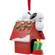 Load image into Gallery viewer,     Snoopy resting on decorated red doghouse ornament with holiday lights
