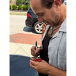 Load image into Gallery viewer, Ian Petrella, who played Randy Parker in A Christmas Story, personally signing a Department 56 Ralphie to the Rescue figurine box at an outdoor signing event
