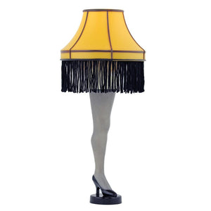 Leg lamp with yellow shade and black fringe on a white background